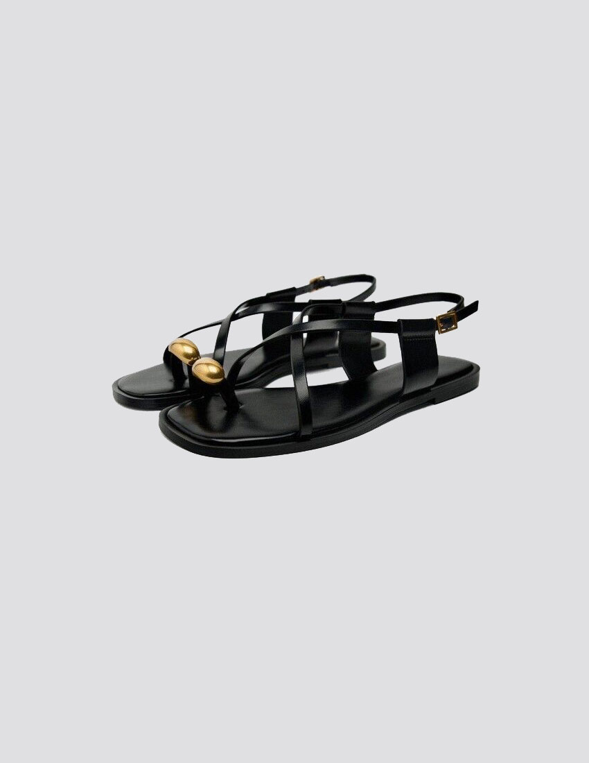 Sandalia plana, en negro con dije dorado en dedo