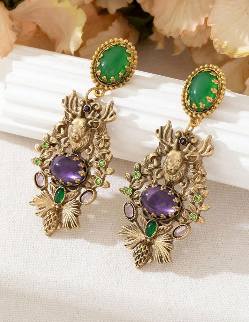 Aretes largos tono oro viejo, diseño de alce  y cristales verdes y  lavanda