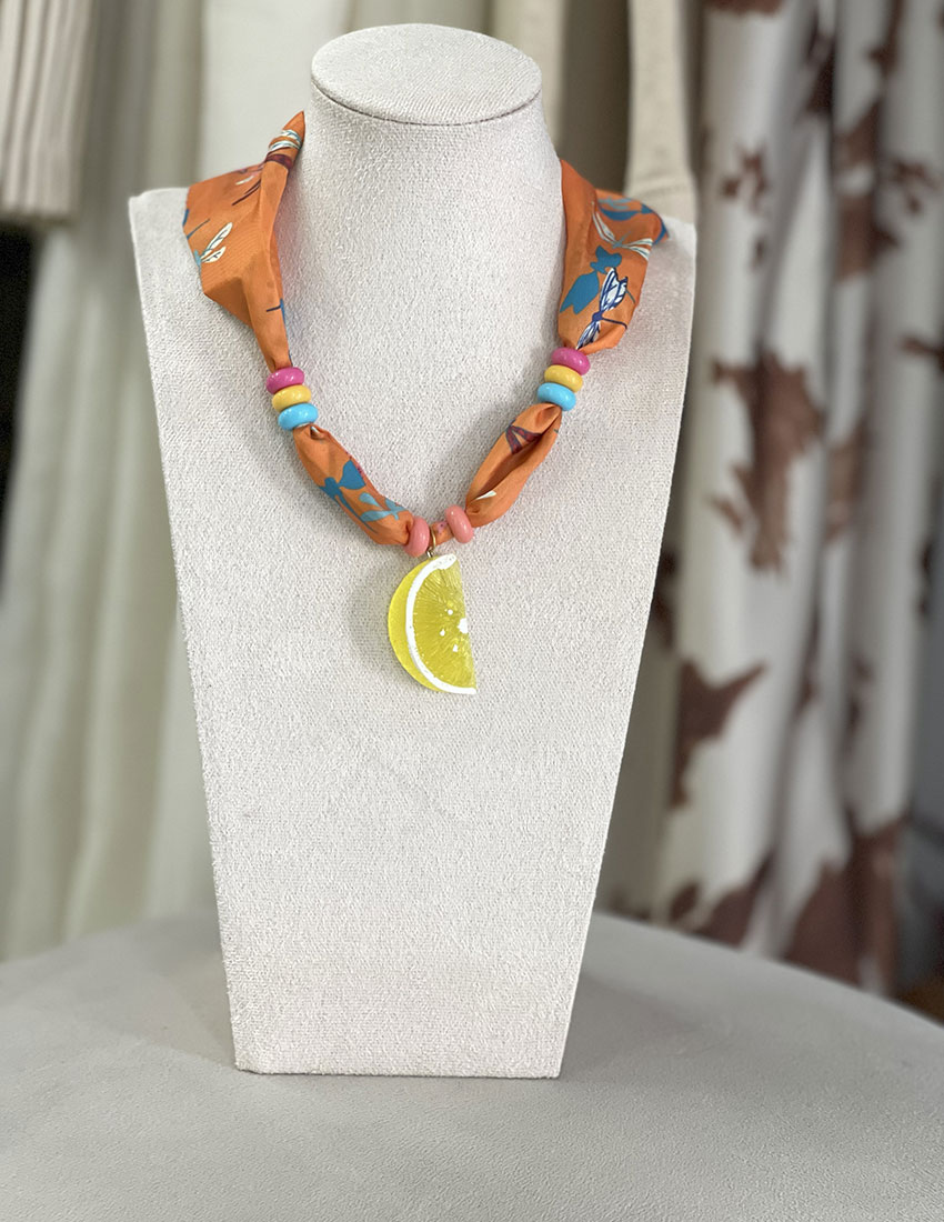 Collar de tela color naranja con dije de limón